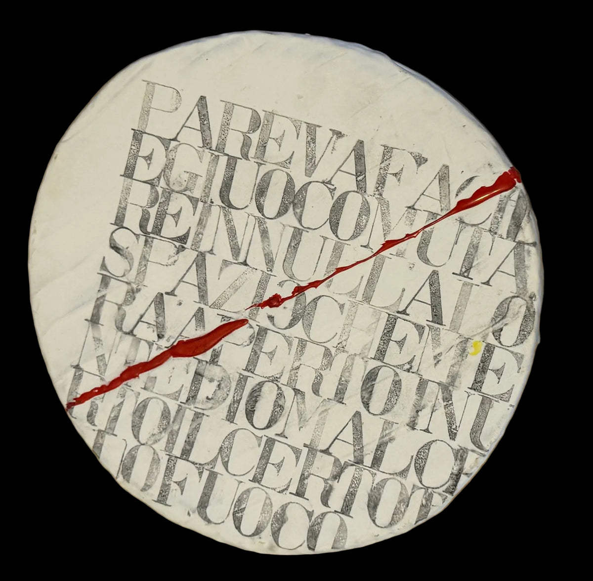 Circular object with text and a red line on a wooden surface